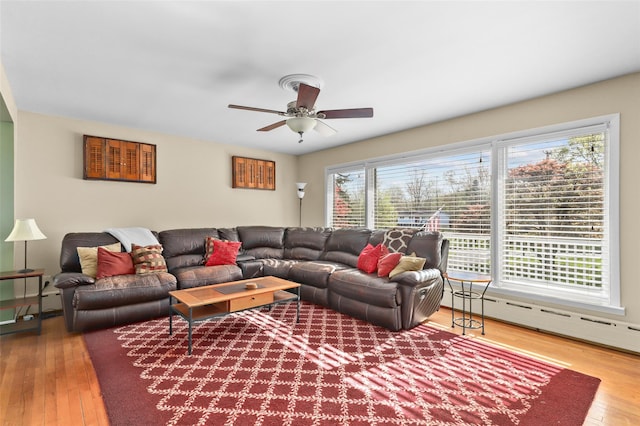 living room featuring ceiling fan, wood-type flooring, and baseboard heating