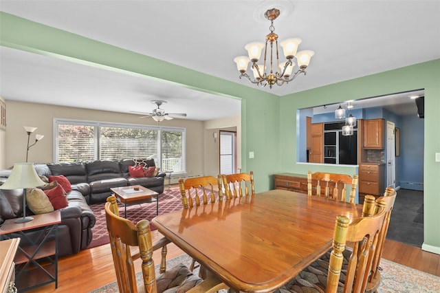 dining space with baseboard heating, a chandelier, and light wood-type flooring