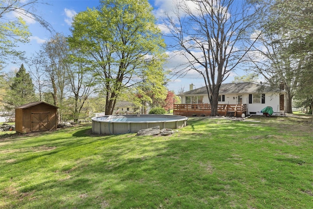 view of yard with a storage shed, an outdoor structure, a deck, and an outdoor pool