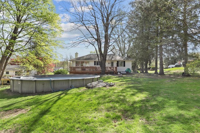 view of yard with a deck and an outdoor pool