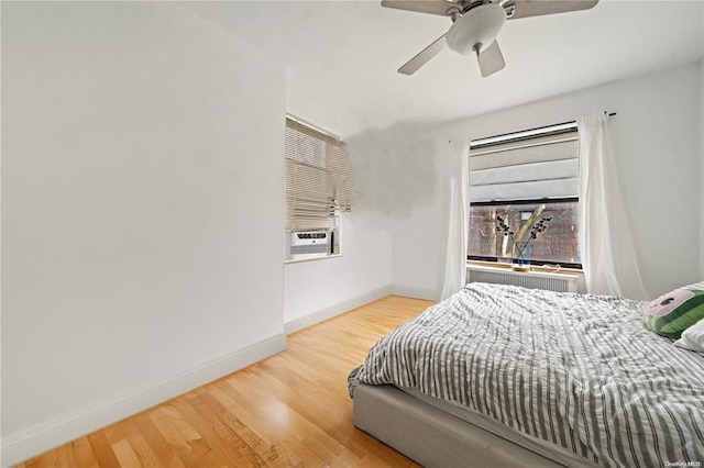 bedroom with wood finished floors, ceiling fan, cooling unit, and baseboards