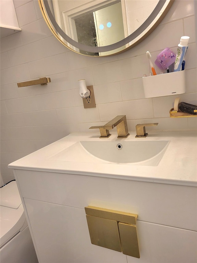 bathroom featuring tile walls, toilet, vanity, and decorative backsplash