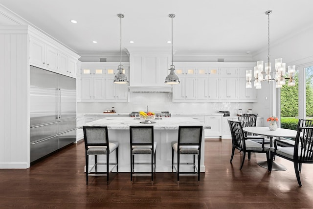 471 Middle Line Hwy, Sag Harbor, NY 11963 - kitchen with a chandelier, stainless steel built in refrigerator, ornamental molding, and white cabinets