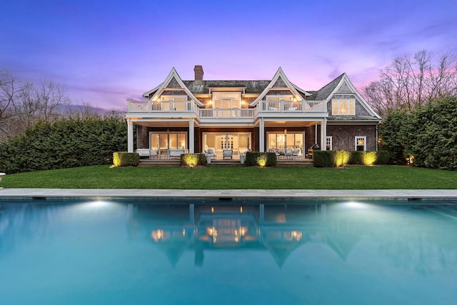 471 Middle Line Hwy, Sag Harbor, NY 11963 - back of property with a chimney, a yard, an outdoor pool, and a balcony