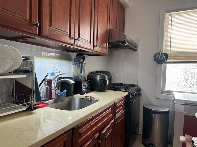 kitchen with black gas stove, a wealth of natural light, under cabinet range hood, and decorative backsplash