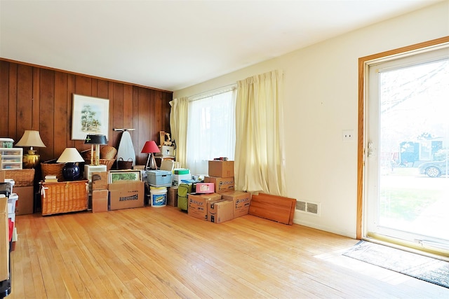 interior space with wood walls, visible vents, and hardwood / wood-style flooring