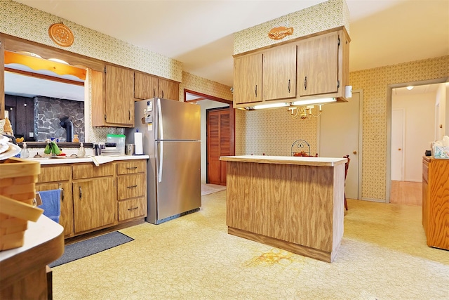 kitchen with wallpapered walls, light floors, and freestanding refrigerator