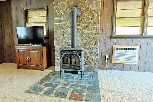 unfurnished living room with wooden walls, a wall mounted AC, and a wood stove
