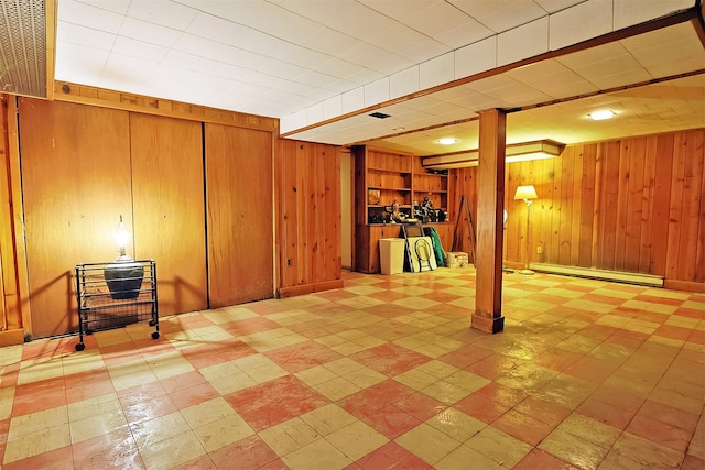 finished basement featuring a baseboard radiator and wooden walls