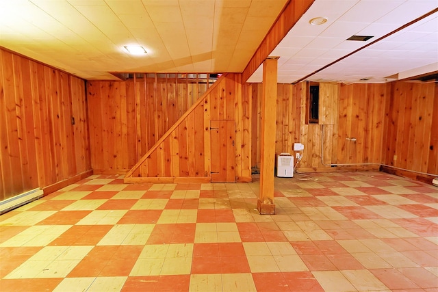 finished basement featuring wooden walls and tile patterned floors