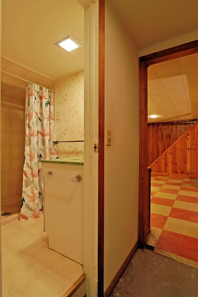interior space featuring baseboards and wood walls