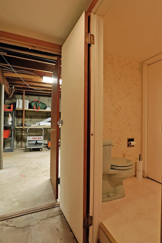 hall with wallpapered walls and concrete floors