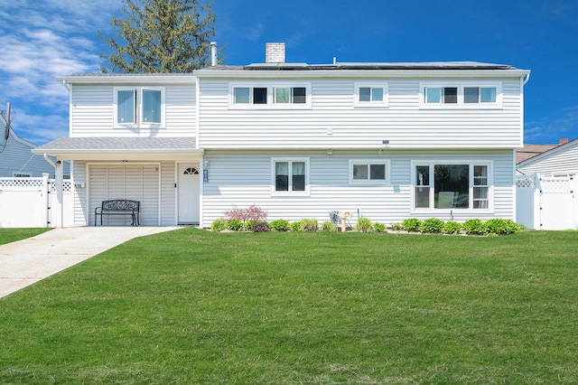 exterior space with a chimney, a gate, fence, a front lawn, and concrete driveway