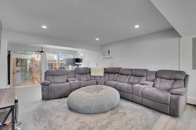 living room featuring recessed lighting, a wall unit AC, and wood finished floors