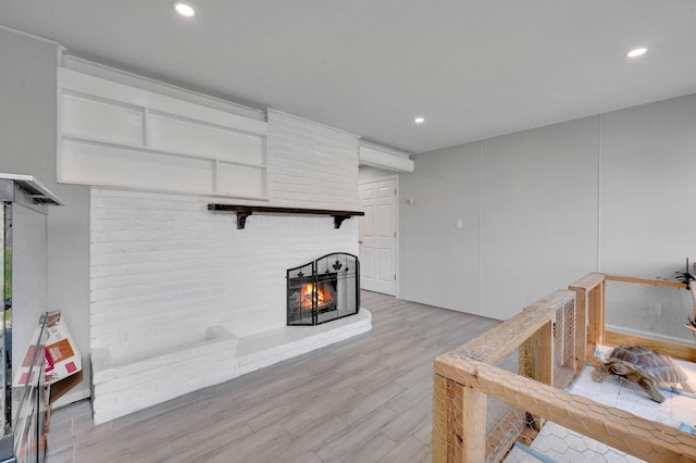 living area featuring a fireplace, recessed lighting, and light wood-style flooring