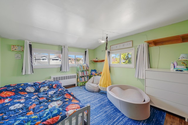 bedroom featuring lofted ceiling and radiator heating unit