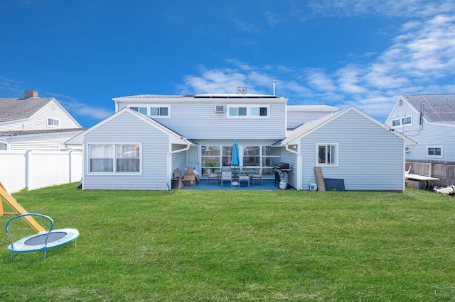 back of property featuring a yard, a fenced backyard, and a patio area