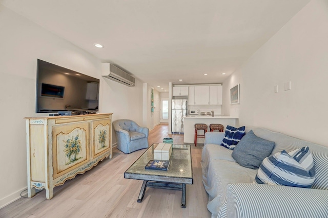 living room featuring an AC wall unit, recessed lighting, light wood-style floors, and baseboards