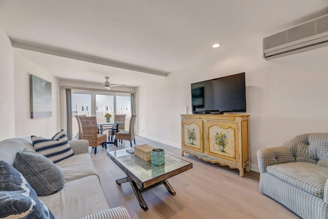 living area featuring a wall mounted air conditioner, a ceiling fan, baseboards, recessed lighting, and light wood-type flooring