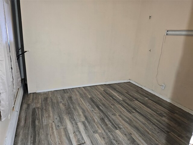 unfurnished room featuring dark wood-style flooring and baseboards