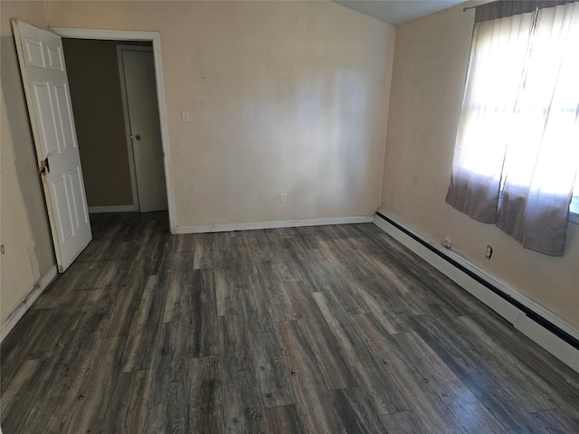 spare room featuring baseboards, baseboard heating, and wood finished floors