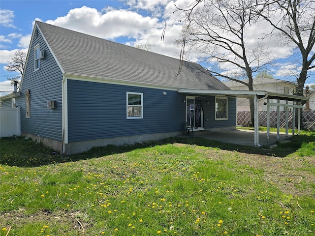 back of property featuring fence, a patio, a shingled roof, and a lawn