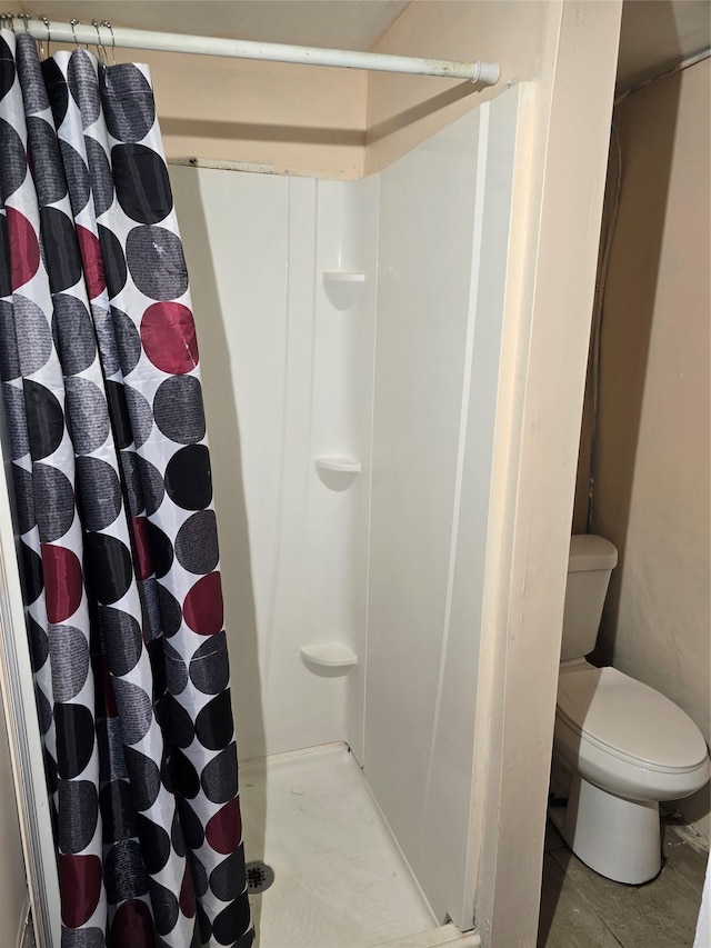 full bathroom featuring a stall shower and toilet