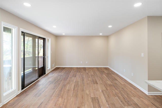 spare room with baseboards, light wood finished floors, and recessed lighting