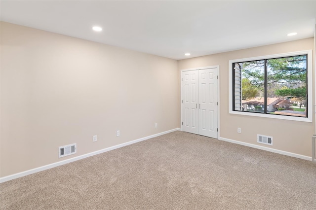 unfurnished bedroom featuring visible vents, recessed lighting, carpet, and baseboards