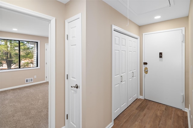 hallway featuring visible vents, baseboards, attic access, recessed lighting, and dark wood finished floors