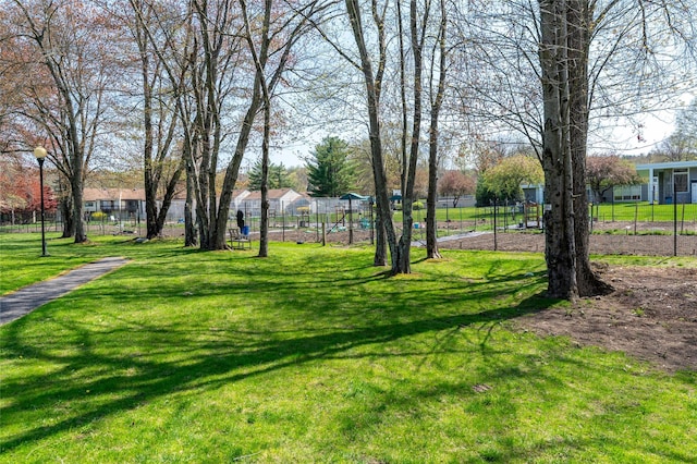 view of community with a lawn and fence