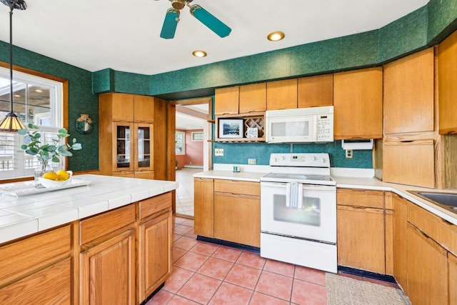 kitchen with light tile patterned floors, tile counters, recessed lighting, white appliances, and a ceiling fan