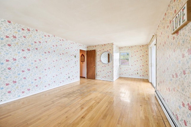 unfurnished room with baseboards, wallpapered walls, baseboard heating, and light wood-style floors