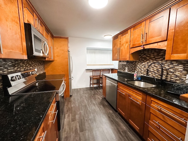 kitchen featuring a sink, tasteful backsplash, stainless steel appliances, and brown cabinets