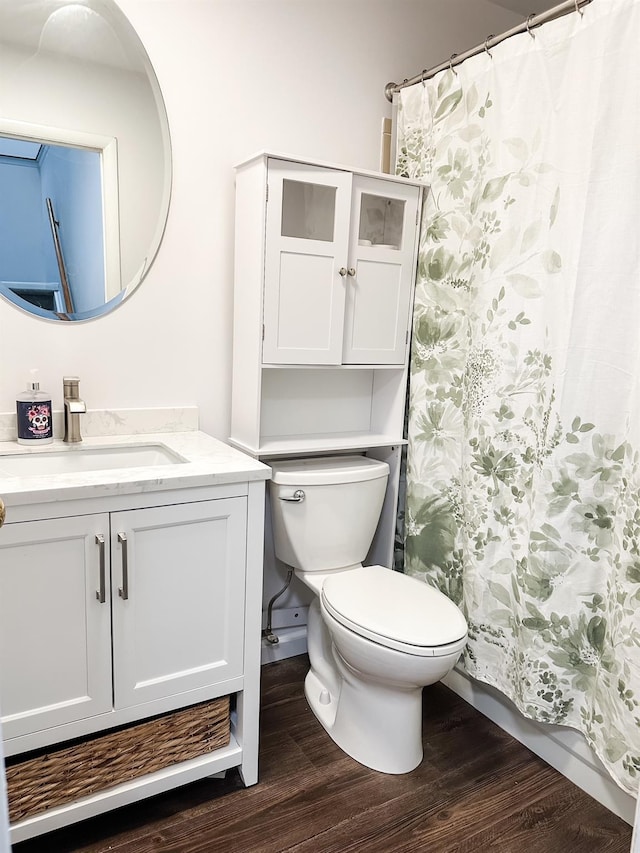 full bathroom featuring toilet, curtained shower, wood finished floors, and vanity