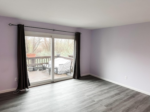 empty room with baseboards and wood finished floors