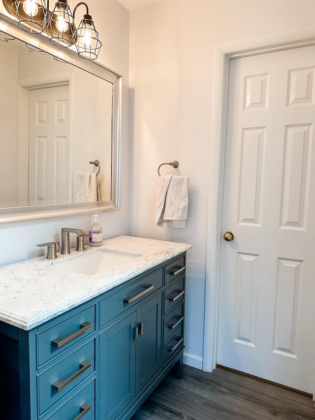 bathroom featuring vanity, wood finished floors, and a chandelier
