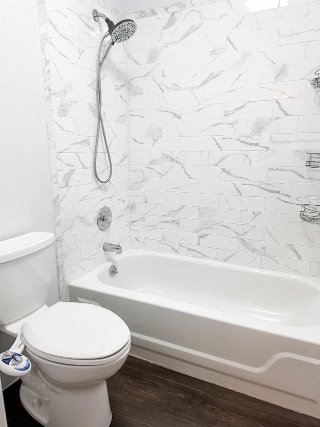 bathroom featuring bathing tub / shower combination, toilet, and wood finished floors