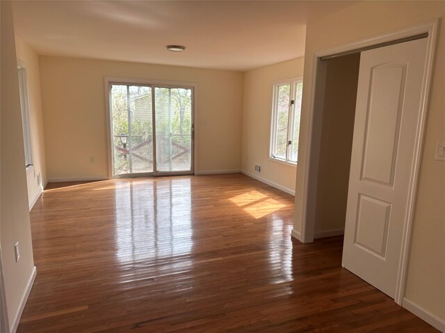 empty room featuring baseboards and wood finished floors