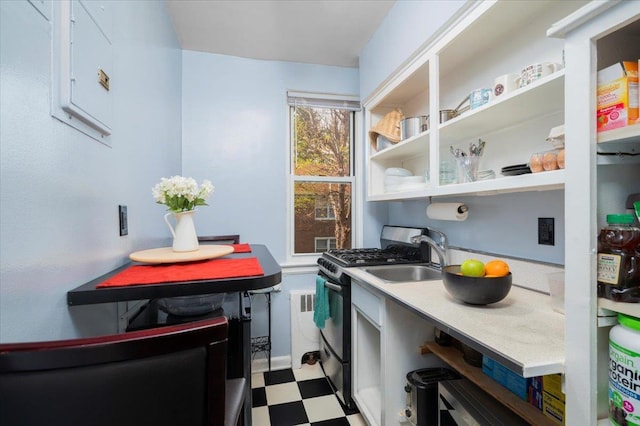 10 Bryant Cres Unit 2A, White Plains, NY 10605 - kitchen featuring open shelves, a sink, stainless steel gas range oven, light countertops, and tile patterned floors