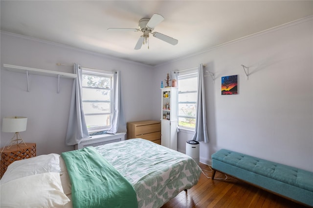 bedroom featuring a ceiling fan, attic access, hardwood / wood-style floors, and multiple windows
