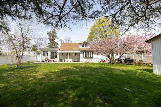 back of house featuring a fenced backyard, a patio, and a yard
