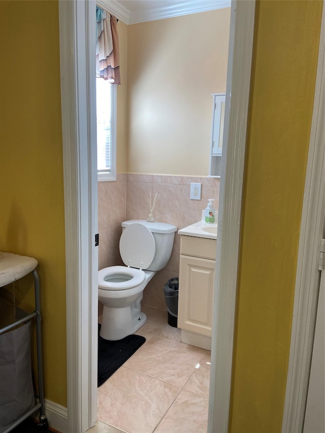 bathroom featuring tile patterned floors, tile walls, toilet, vanity, and crown molding