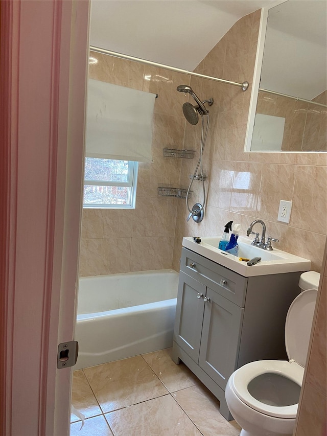 full bathroom with tile walls, toilet, bathing tub / shower combination, tile patterned floors, and vanity