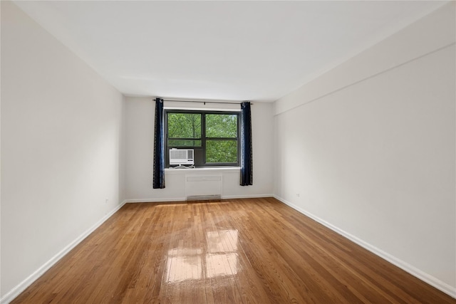 212-03 75th Ave Unit 5A, Bayside, NY 11364 - spare room featuring wood finished floors, baseboards, and cooling unit