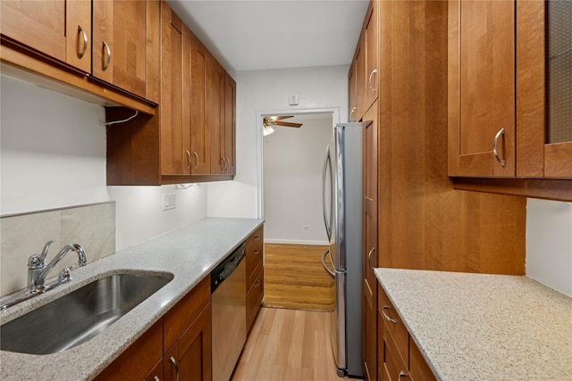 212-03 75th Ave Unit 5A, Bayside, NY 11364 - kitchen with appliances with stainless steel finishes, a sink, light wood-style flooring, brown cabinetry, and light stone counters