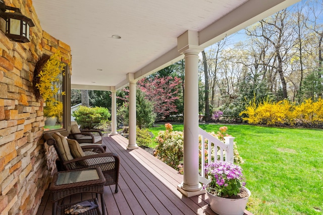 deck with a porch and a lawn