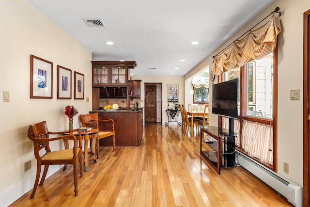 interior space with light wood finished floors, recessed lighting, visible vents, and a baseboard radiator