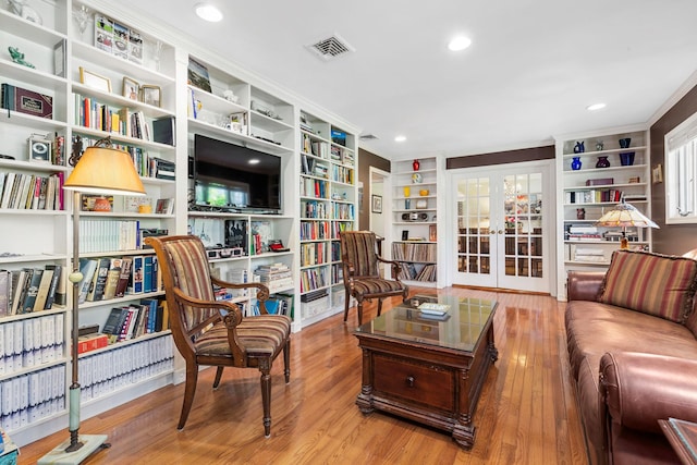 interior space featuring ornamental molding, french doors, wood finished floors, and visible vents