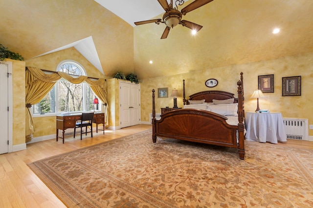 bedroom with baseboards, radiator heating unit, wood finished floors, and vaulted ceiling